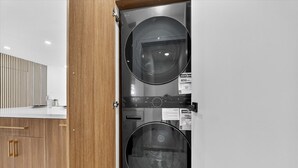 Eine moderne Küche mit Holzschränken, einem Edelstahlgerät und einer Arbeitsplatte mit einem Glasbehälter.