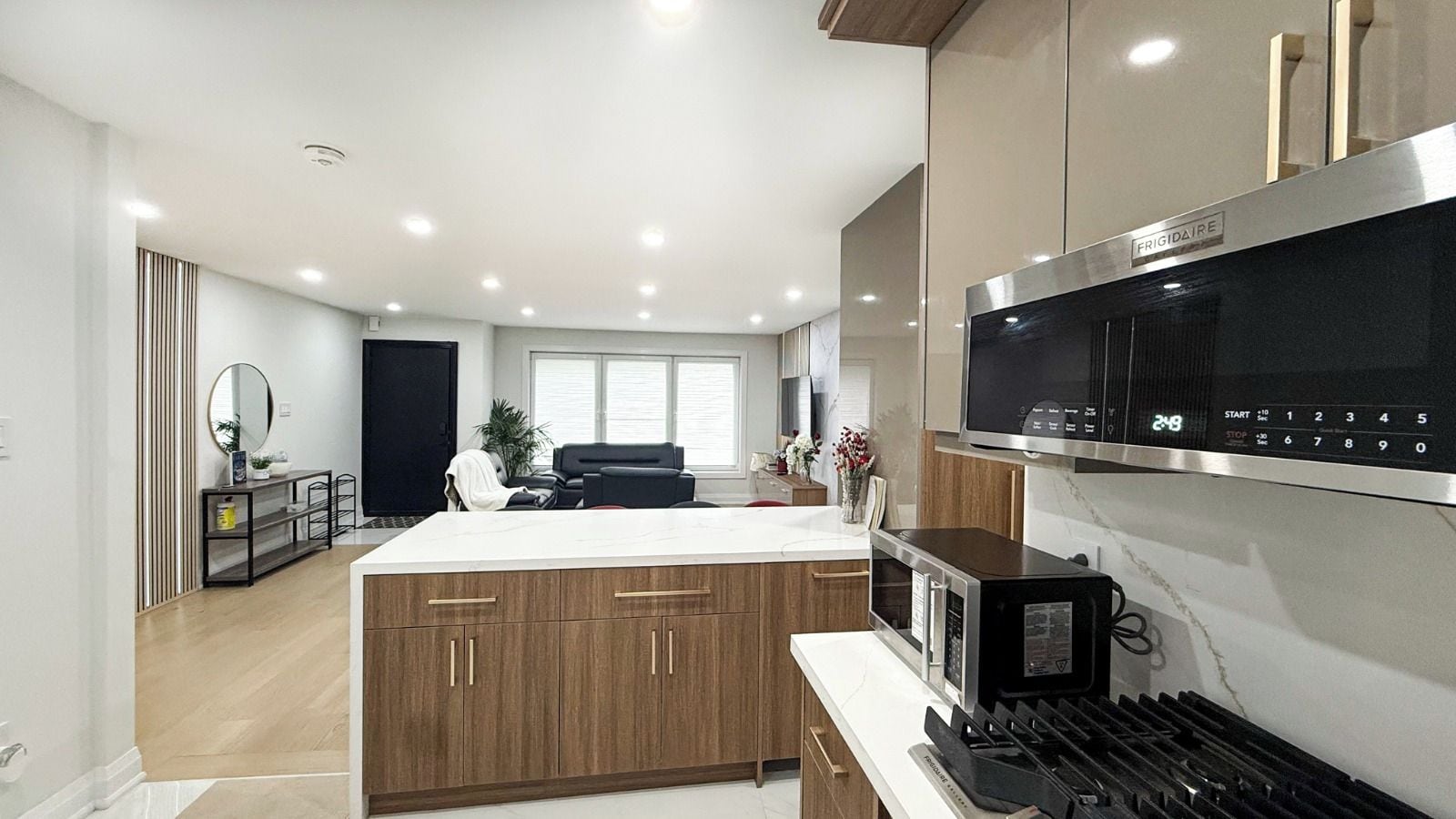 Una cocina moderna con una isla central, electrodomésticos de acero inoxidable y armarios de madera.