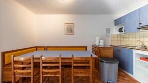 A compact kitchen with a dining table, chairs, a trash bin, and a sink. - Spacious Alpine Triplex With Terrace (Guillaumes)
