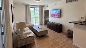 Ein modernes Wohnzimmer mit Sofa, Couchtisch und Fernseher.