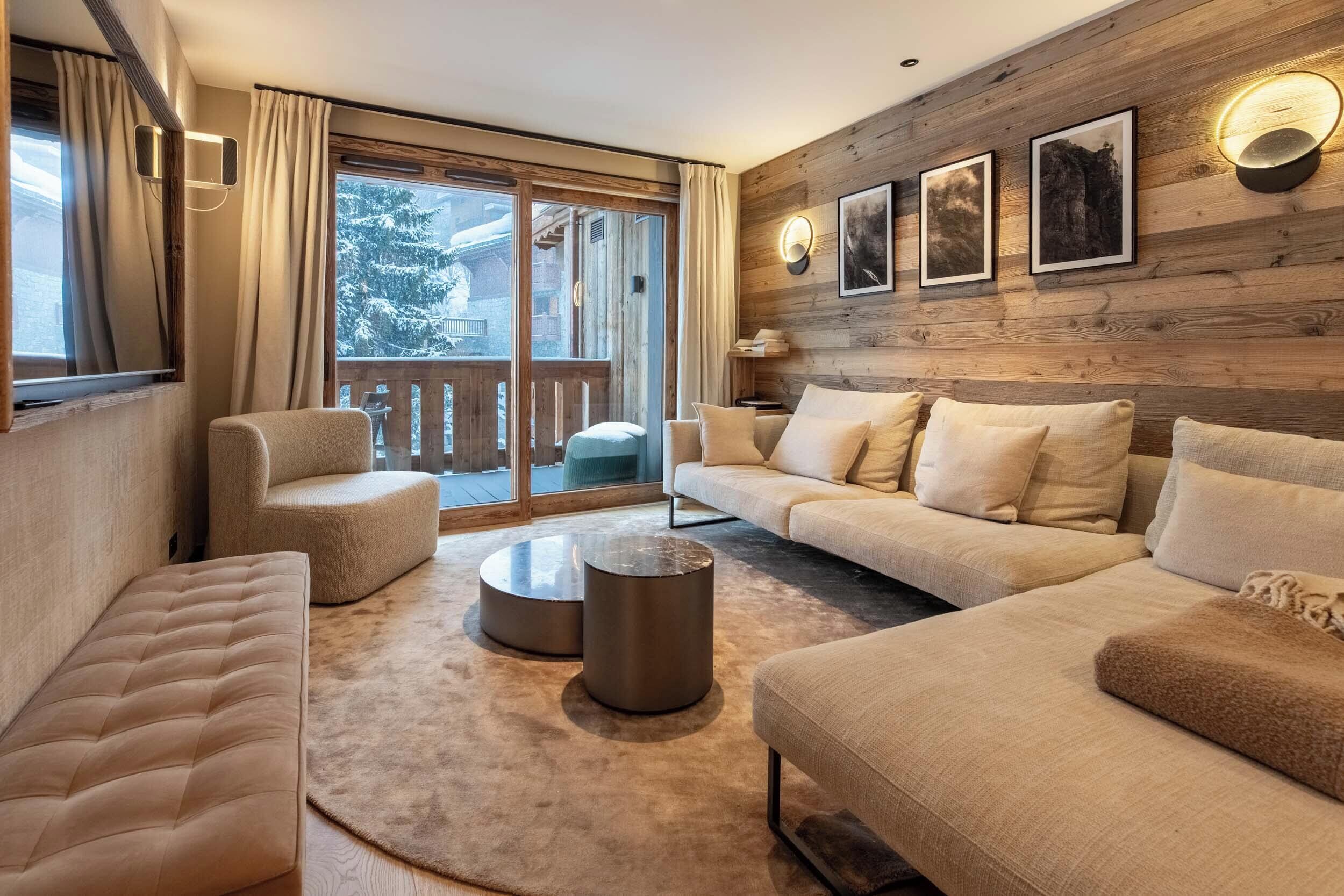 A modern living room with a sofa, armchair, and round coffee table.