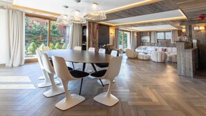A spacious living area with a large wooden herringbone floor, a dining table with chairs, a sofa set, and a fireplace. - Flocon - Ours Rouge: an exceptionally spacious apartment with a jacuzzi (Les Allues)
