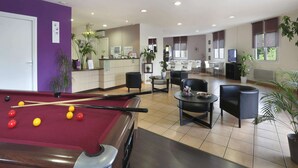 A pool table with balls, a reception desk, a dining area with chairs, and a TV. - Large Mezzanine Stay for 6 in Merville (Merville)