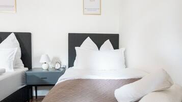 Una camera d'albergo con un letto, due comodini e due poster motivazionali appesi alla parete.