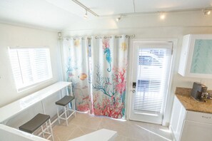 A room with a white desk, two chairs, a coffee maker, and a door with a frosted glass window. - Beachside Bungalow! Steps to Ocean + Bay /Sleeps 6 (San Diego)
