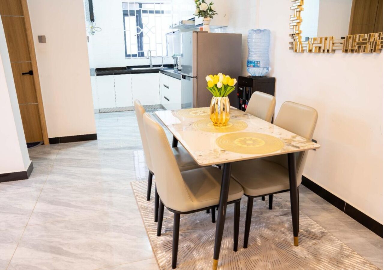 A dining area with a table, chairs, and a vase of flowers.