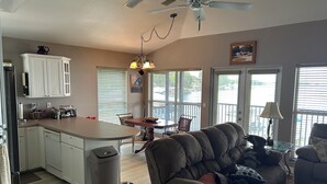 A modern kitchen with a dining area, a ceiling fan, and a view through the windows. - Cozy Snowbird Retreat on Beautiful Lake June. Monthly Winter Rates (Lake Placid)