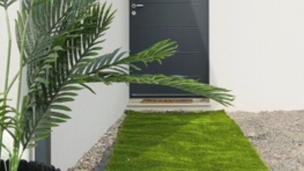 A modern building with a dark door, a small grassy area, and a potted plant. - New house Bretignolles sur Mer 1,5Km from the beach (Bretignolles-sur-Mer)