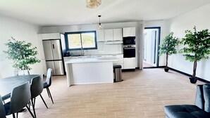 A spacious kitchen with a central island, modern appliances, and a dining area with chairs. - New house Bretignolles sur Mer 1,5Km from the beach (Bretignolles-sur-Mer)
