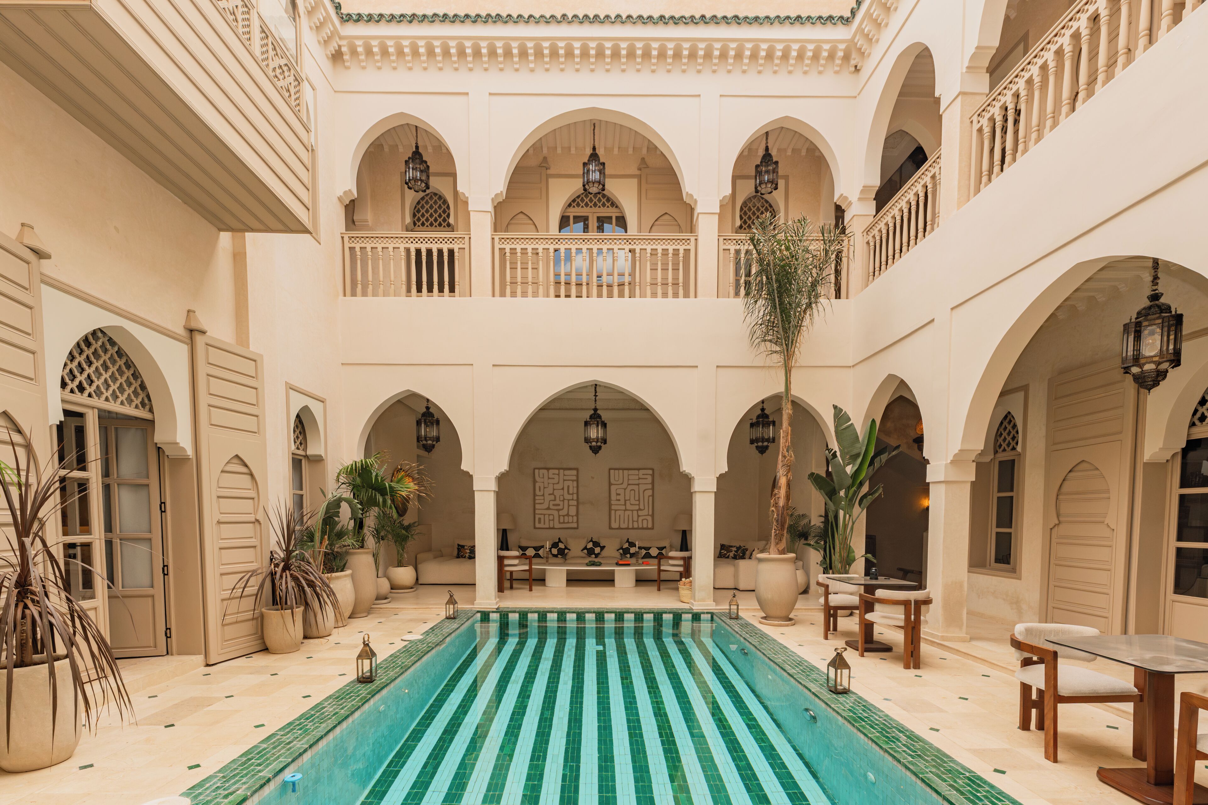 A courtyard with a swimming pool, multiple balconies, and seating areas.