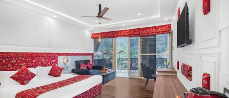 Un dormitorio con cama, escritorio, silla, ventilador de techo y ventana con vistas al exterior.