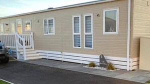 Ein Bungalow mit Veranda, Auffahrt und kleinem Garten.