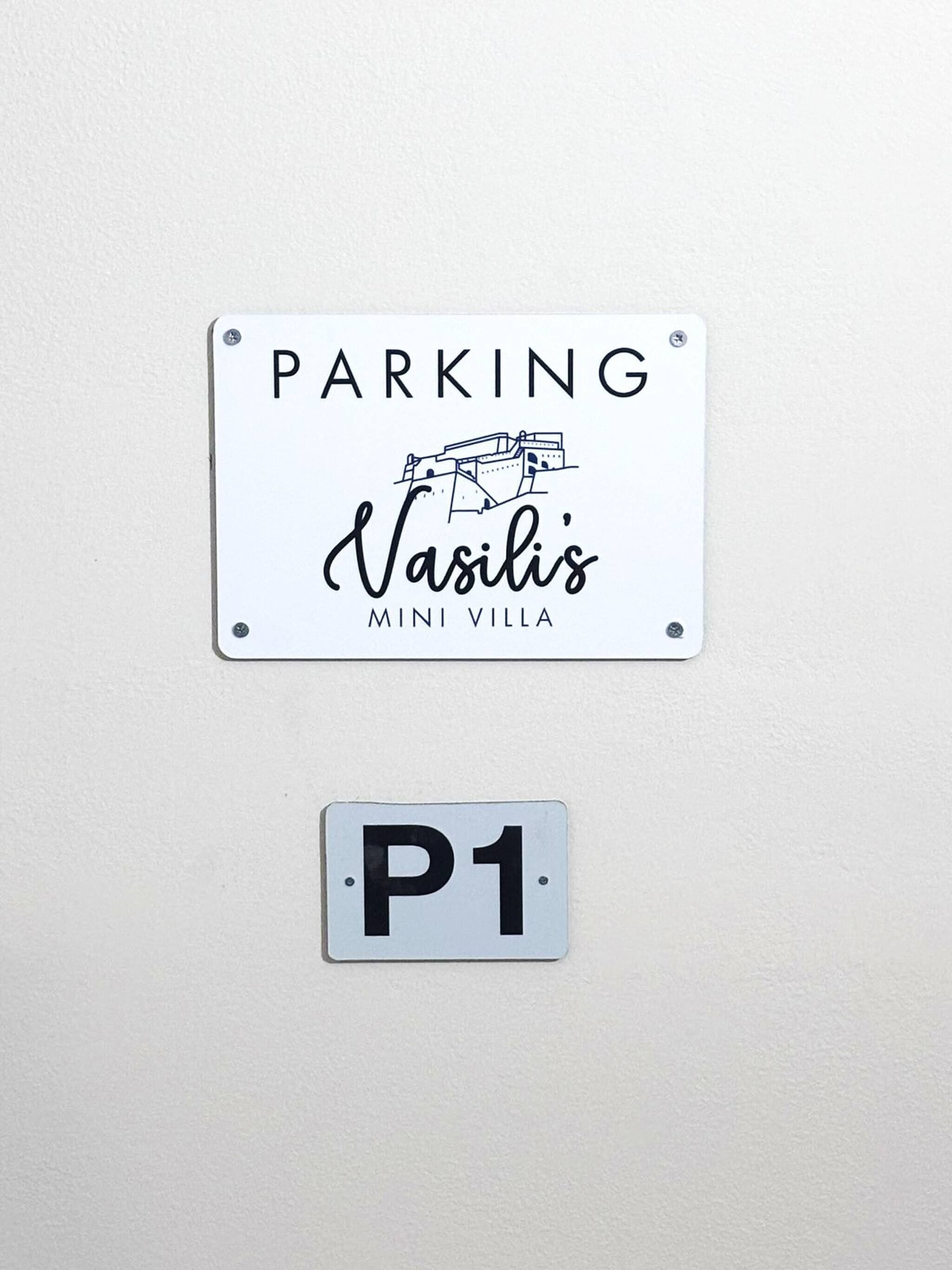 Ein Schild, das Parkplätze für Vasili's Mini Villa kennzeichnet.