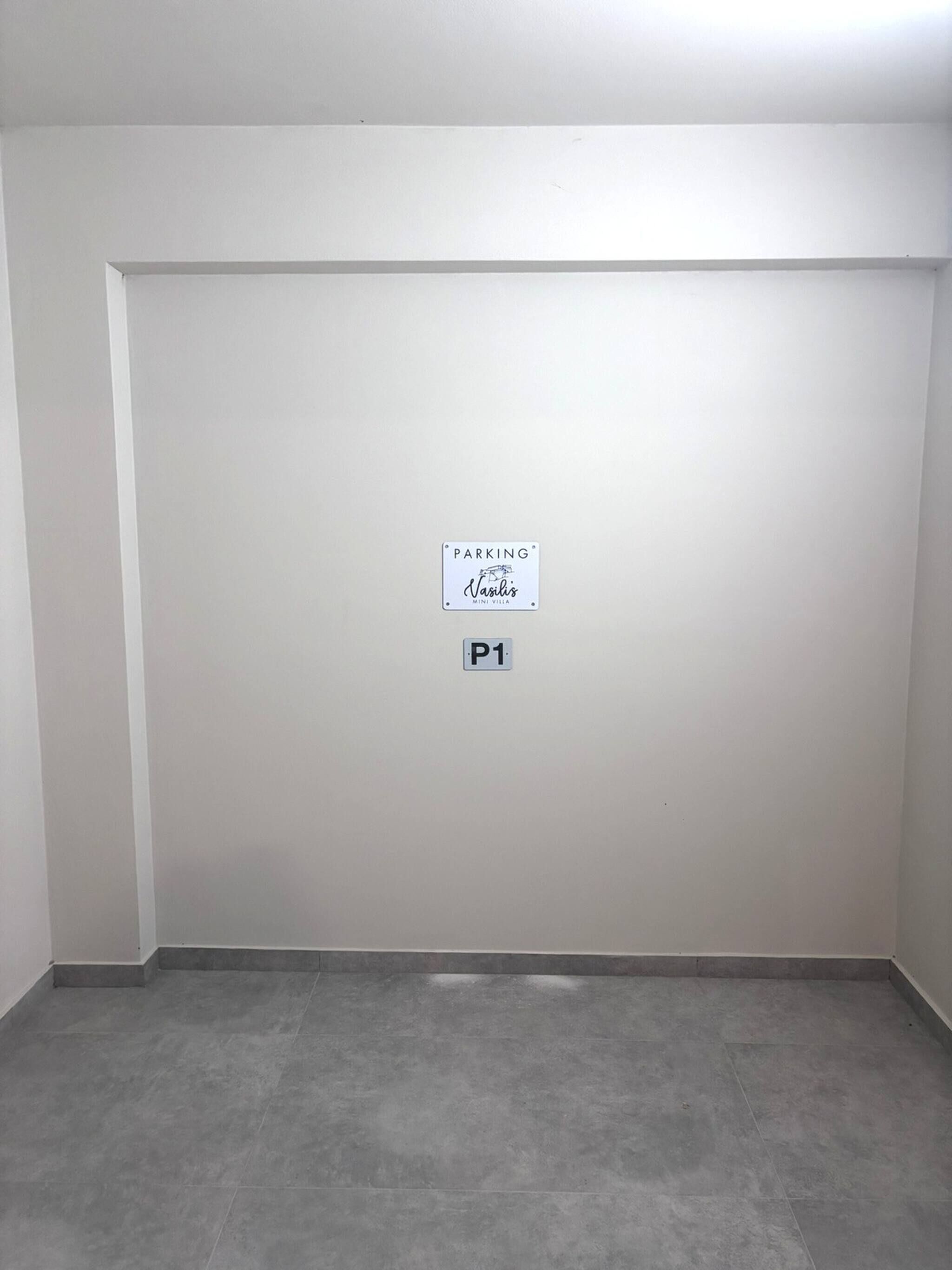 A plain white wall with a parking sign and a P1 label.