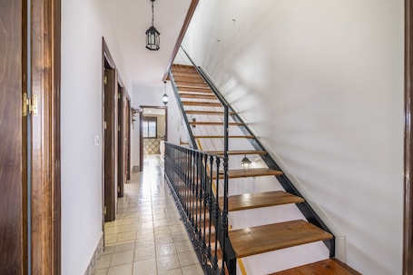 Eine Treppe mit Holzdielen und schwarzen Metallgeländern, die zu einer Zwischenebene mit einer Tür führt.. El Corralón de Severo – Geräumiges Landhaus für Gruppen