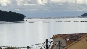 A coastal view with a building, a body of water, and a distant landmass. - Apartment with sea view (Campelo)