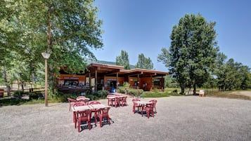 A rustic wooden building with outdoor seating and a sign for 'Accueil - Informations.'