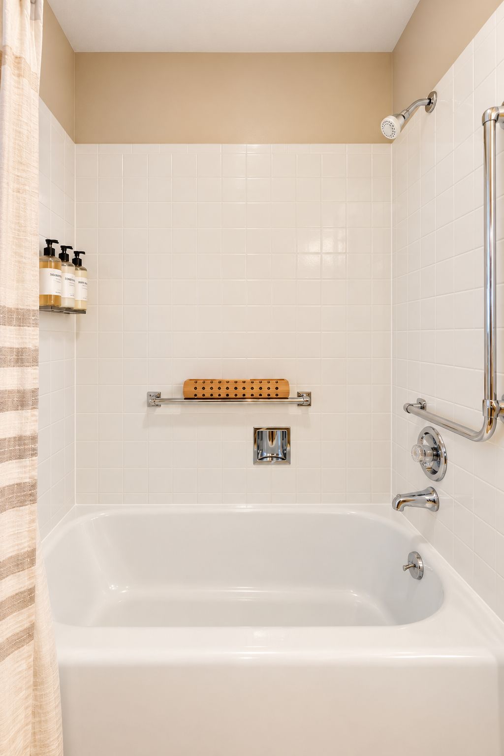 A modern bathroom with a bathtub, a shower, and a handrail.