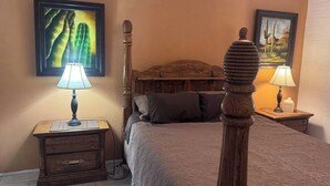 A bedroom with a four-poster bed, wooden nightstands, and two wall-mounted lamps. - Cozy 1-bedroom villa in gorgeous Green Valley with AC (Green Valley)
