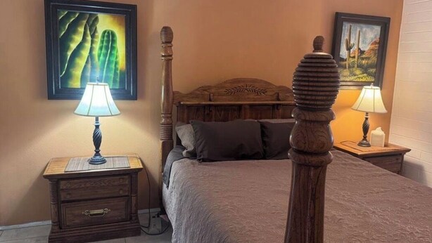 A bedroom with a four-poster bed, wooden nightstands, and two wall-mounted lamps. - Cozy 1-bedroom villa in gorgeous Green Valley with AC (Green Valley)