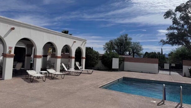 A pool area with lounge chairs and a building with arches. - Cozy 1-bedroom villa in gorgeous Green Valley with AC (Green Valley)
