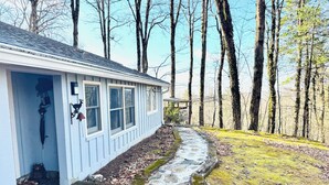 Una casa con un camino de piedra que conduce a la entrada, rodeada de árboles.