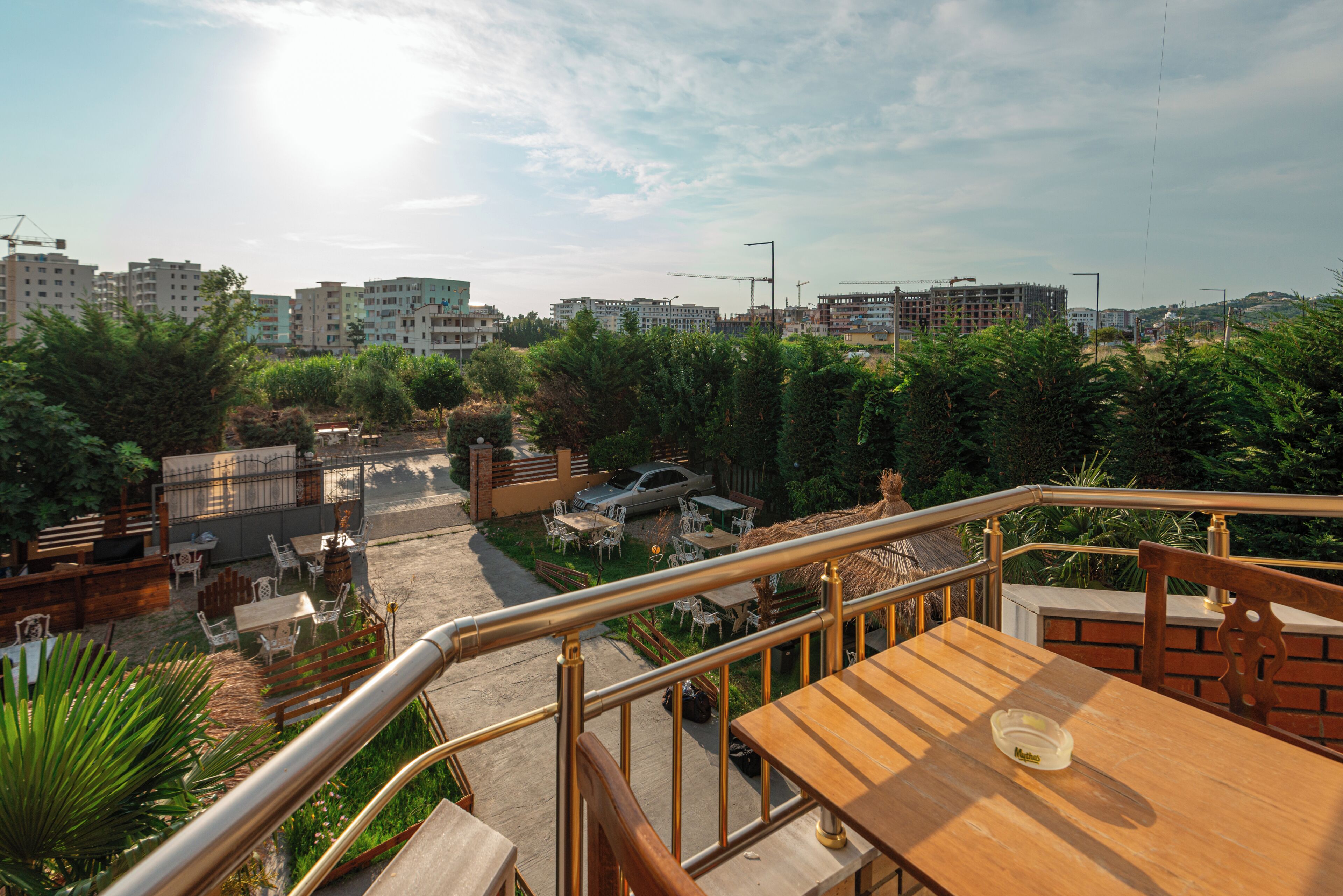 Una terrazza con posti a sedere all'aperto, un'auto e vegetazione circostante.