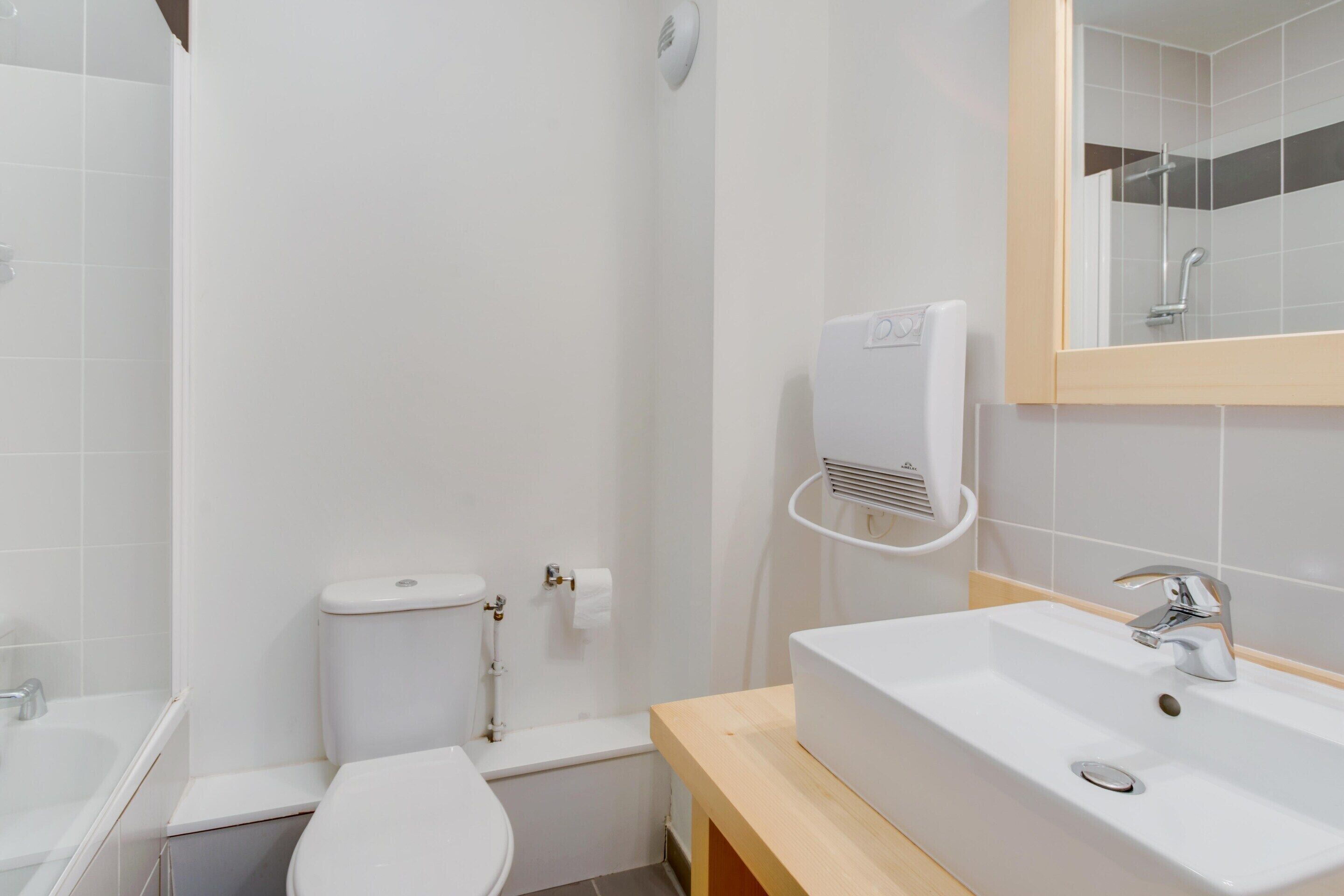 A bathroom with a toilet, sink, and shower.
