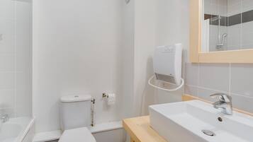 A bathroom with a toilet, sink, and shower.
