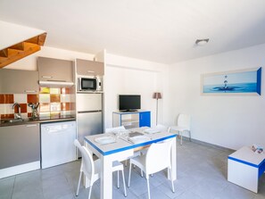 A compact kitchen with a microwave, stove, and dishwasher, a dining area with a table and chairs, and a TV in the corner. - Spacious House for 6 in Parentis (Parentis-en-Born)