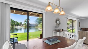 Un espace repas comprenant une table, des chaises, un banc et une vue sur un lac.
