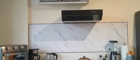 Cocina compacta con horno integrado, microondas y cafetera.