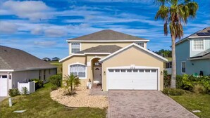 A single-story house with a garage, a front yard with a palm tree, and a mailbox.