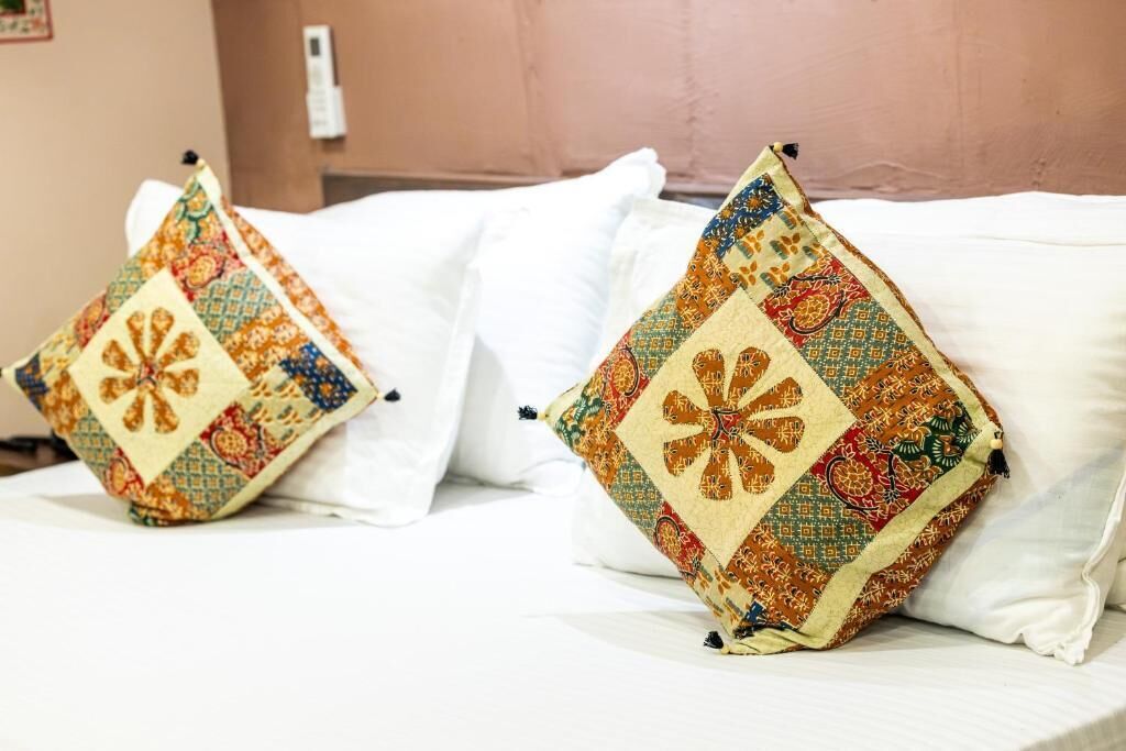 Una cama con dos almohadas de diseño geométrico.