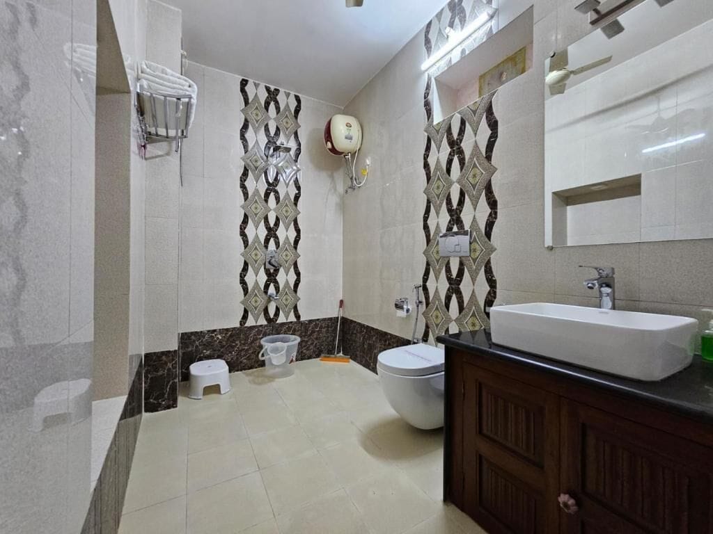 A bathroom with a toilet, sink, and shower area.
