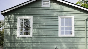 A green single-story house with a front door, two windows, and a small porch area. - Harriss-James Carriage House Unit B, 0.3 Mi from Historic Downtown (Wilmington)