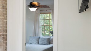 A bedroom with a bed, a ceiling fan, a window with curtains, and a TV mounted on the wall. - Harriss-James Carriage House Unit B, 0.3 Mi from Historic Downtown (Wilmington)