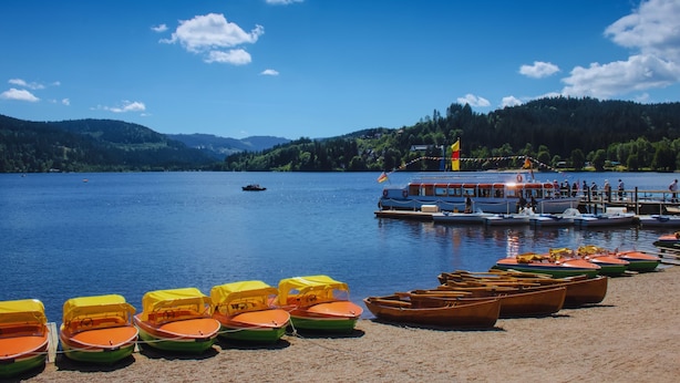 Un cadre idyllique au bord du lac, avec des bateaux et un quai.