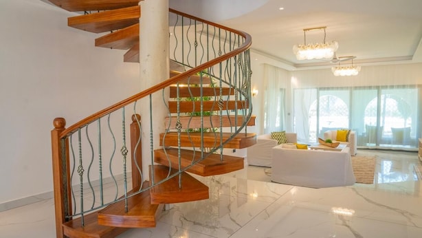 A modern interior with a spiral staircase, a marble floor, and a seating area with a white sofa and a coffee table. - Creek Side, Ocean View 5-bedroom villa, with a private Coastal feel in Mombasa (Mombasa)