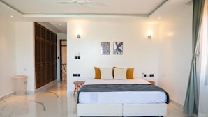 A bedroom with a large bed, a ceiling fan, and a view of a hallway. - Creek Side, Ocean View 5-bedroom villa, with a private Coastal feel in Mombasa (Mombasa)