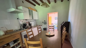 Een keuken met een eettafel, stoelen en een tegelvloer.