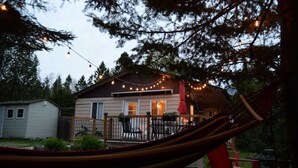 A house with a deck, string lights, and a hammock.