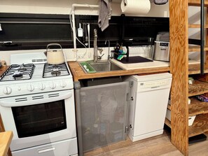 A compact kitchen with a stove, oven, sink, and a small refrigerator. - 2 Bed 1 Futon Loft Apartment (San Diego)