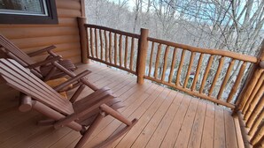 A wooden deck with Adirondack chairs and a wooden railing. - B cabin 2-bedroom with AC in charming Blowing Rock (Blowing Rock)