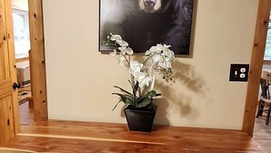 A rustic wooden desk with a bear portrait, a potted plant, and a light switch on the wall. - B cabin 2-bedroom with AC in charming Blowing Rock (Blowing Rock)