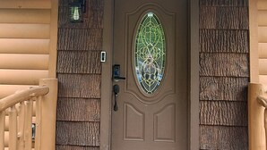 A wooden cabin with a deer head mounted above the door, a number '259' sign, a stained glass window, and a wooden railing. - B cabin 2-bedroom with AC in charming Blowing Rock (Blowing Rock)