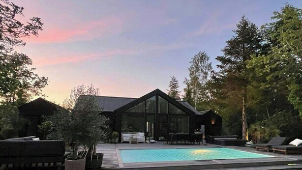 A modern house with a swimming pool, surrounded by a well-maintained lawn and trees. - Modern holiday home by Holbæk Fjord (Holbæk)