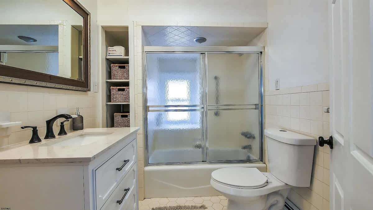 A bathroom with a shower, toilet, and sink.