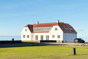 A white house with a red roof, a garage, and a car parked in front. - Villa with fjord view by Frederik VII's Canal (Løgstør)