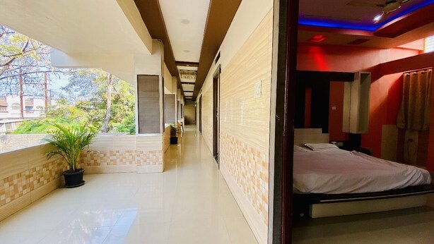 Un pasillo de hotel con una cama, una planta en maceta y vistas al exterior.